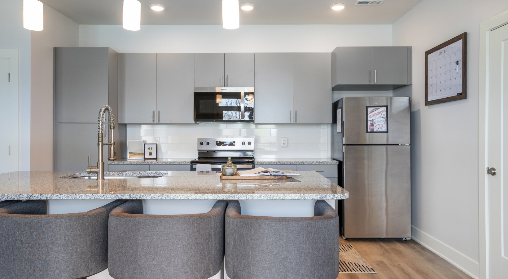 Staged apartment kitchen with island and desk